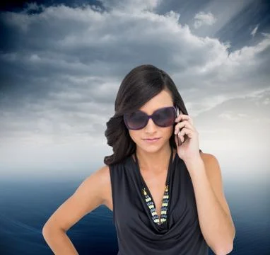 Composite image of serious elegant brunette wearing sunglasses on the phone Stock Illustration