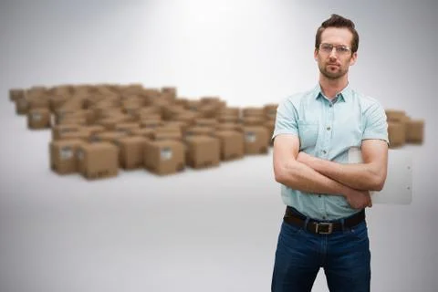 Composite image of serious warehouse manager standing with arms crossed Fotos de archivo