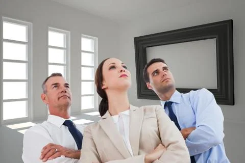 Composite image of serious work team posing together looking away Illustrazione stock
