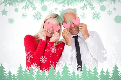 Composite image of silly couple holding hearts over their eyes Ilustração Stock