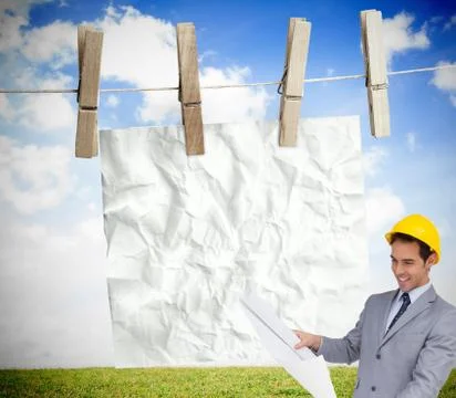 Composite image of smiling architect with hard hat looking at plans Stock Illustration