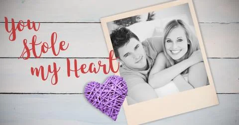 Composite image of smiling beatiful couple sitting on a sofa Stock Photos