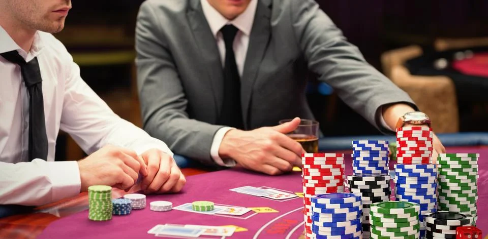 Composite image of stack of colorful casino tokens with red dice Stock Photos