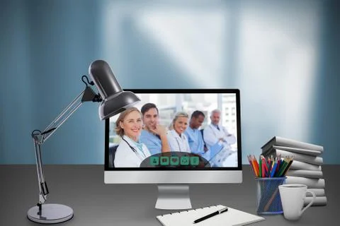 Composite image of table lamp by computer and books Foto stock