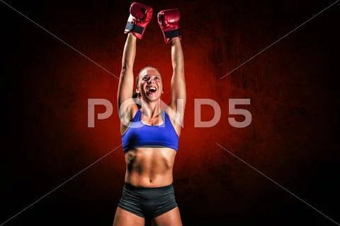 Composite image of winning fighter with arms raised Stock Photos