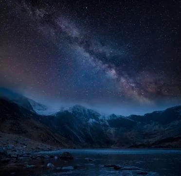 Composite image of Winter landscape of snowcapped Mountain Range at night wit Stock Photos