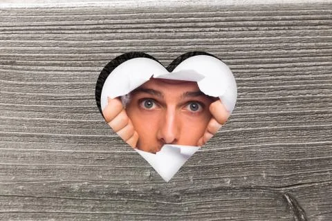 Composite image of young man looking through paper rip イラスト素材