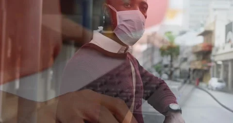 Composite video of african american man wearing face mask against mid section of Stock Footage 330779853
