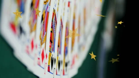 Composite video of multiple golden star icons falling against playing cards on Stock Footage 312409760