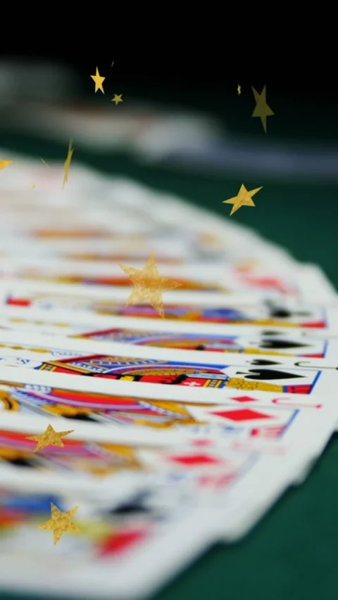 Composite video of multiple golden star icons falling against playing cards on Stock Footage 324433009