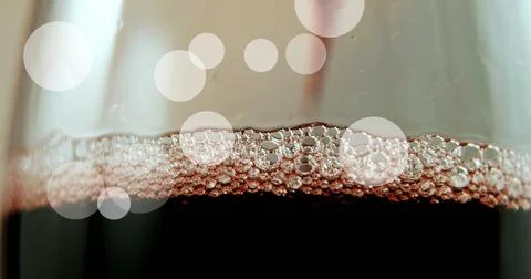 Composite of white spots of light over red wine in glass Ilustração Stock