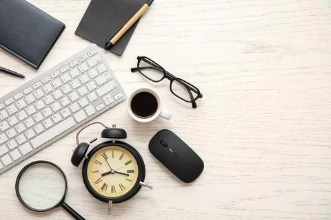 Composition with alarm clock, computer keyboard and cup of coffee on white wo Stock Photos