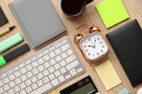 Composition with alarm clock, computer keyboard and stationery on beige woode Stock Photos