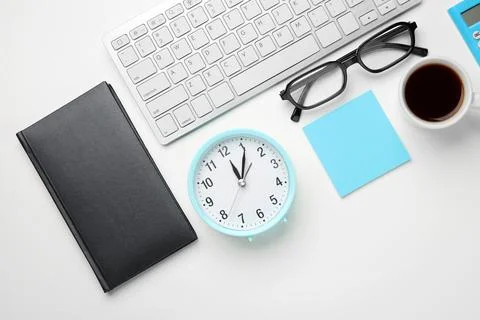 Composition with alarm clock, computer keyboard and cup of coffee on white ba Stock Photos