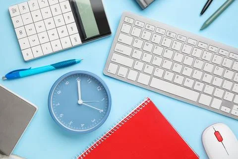 Composition with alarm clock, computer keyboard and mouse on blue background, Stock Photos