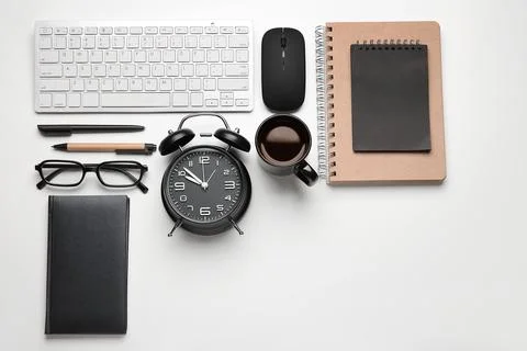 Composition with alarm clock, cup of coffee, computer keyboard and mouse on w Stock Photos
