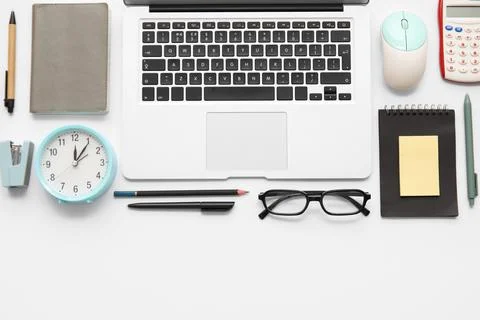 Composition with alarm clock, modern laptop and stationery on white backgroun Stock Photos