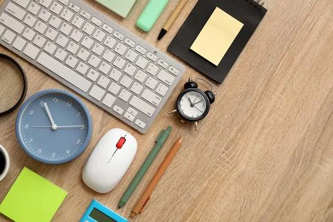 Composition with alarm clocks, computer keyboard and mouse on beige wooden ba Stock Photos