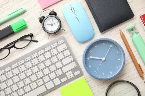 Composition with alarm clocks, stationery, computer keyboard and mouse on whi Stock Photos