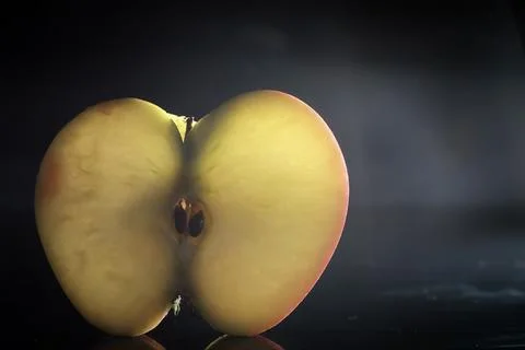 Composition with apple slices on a black background. A slice of apple with ba Stock Photos