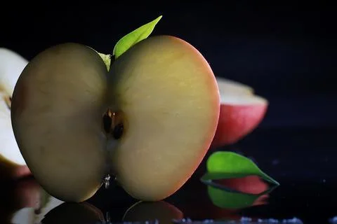 Composition with apple slices on a black background. A slice of apple with .. Foto stock