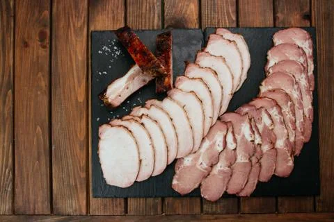 Composition of aromatic, smoked cold cuts wooden background. Stockfoto's