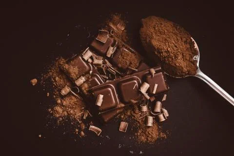 Composition of bars and pieces of different milk and dark chocolate, grated c Stock Photos