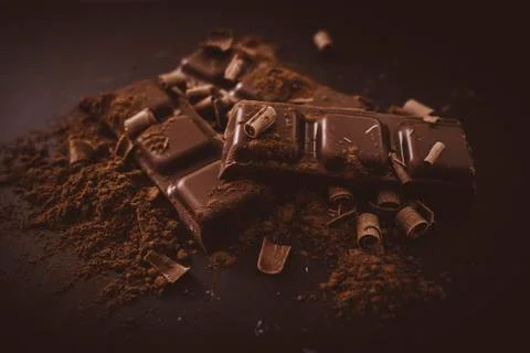 Composition of bars and pieces of different milk and dark chocolate, grated c Stock Photos