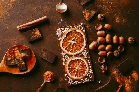 Composition of bars and pieces of different dark chocolate with orange slices Stock Photos