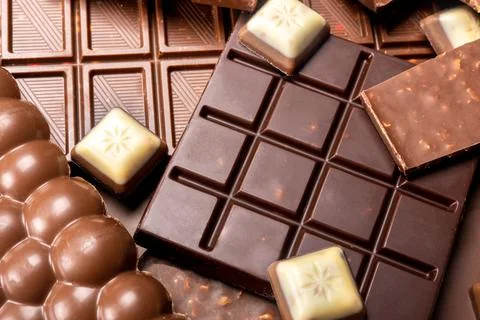 Composition of bars and pieces of different milk and dark chocolate. Assorted Stock Photos