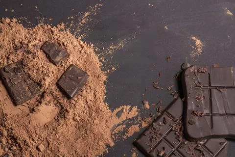 Composition of bars and pieces of different milk and dark chocolate, grated c Stock Photos
