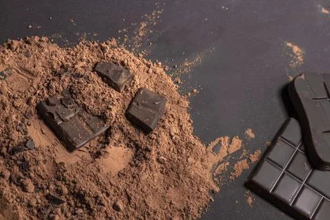 Composition of bars and pieces of different milk and dark chocolate, grated c Stock Photos