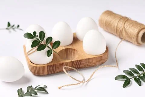 Composition with beautiful Easter eggs, threads and green twigs isolated on w Stock Photos