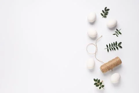 Composition with beautiful Easter eggs, threads and green twigs isolated on w Stock Photos