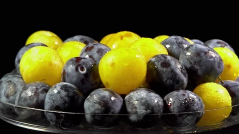 Composition of berries on a rotating table, yellow plum and purple prunes Stock Footage 165077053