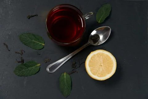 Composition of a black tea with mint and lemon on a dark background Stock Photos