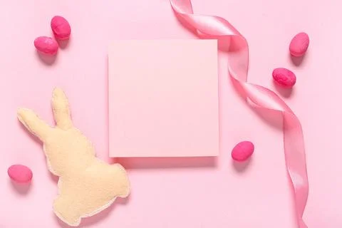 Composition with blank card, decorative bunny and Easter eggs on pink backgro Stock Photos