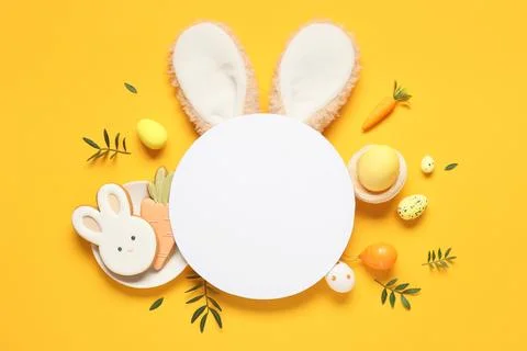 Composition with blank card, Easter eggs, cookies and green leaves on yellow  Stock Photos