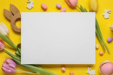 Composition with blank card, Easter eggs and tulip flowers on yellow backgrou Stock Photos