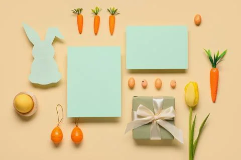 Composition with blank cards, Easter eggs, gift box and tulip flower on beige Stock Photos