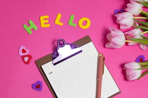 Composition with blank, word Hello and beautiful tulip flowers on pink back.. Stock Photos