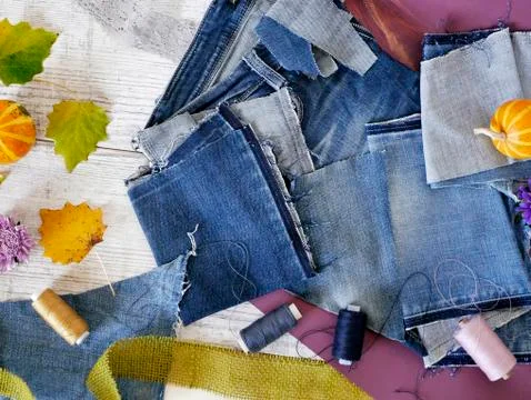 Composition of blue fabric of jeans, threads, autumn leaves, pumpkins Stock Photos