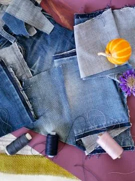 Composition of blue fabric of jeans, threads, autumn leaves, pumpkins Stock Photos