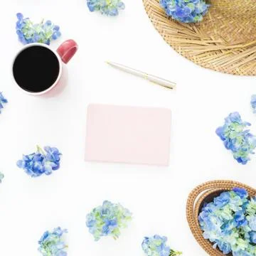 Composition of blue flowers with straw, diary and mug of coffee on white back Foto stock