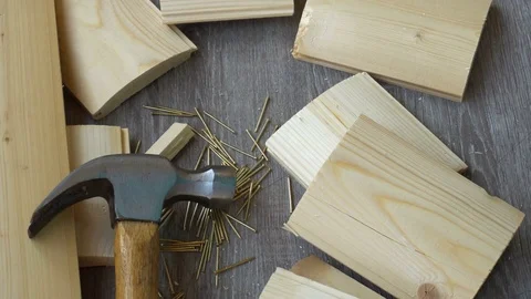 Composition of boards, nails and hammer,hand hammer puts in the frame Stock Footage 76632785