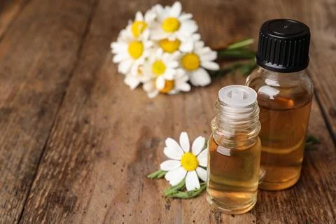 Composition with bottles of chamomile essential oil on table. Space for text Stock Photos