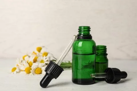 Composition with bottles of chamomile essential oil on table. Space for text Stock Photos