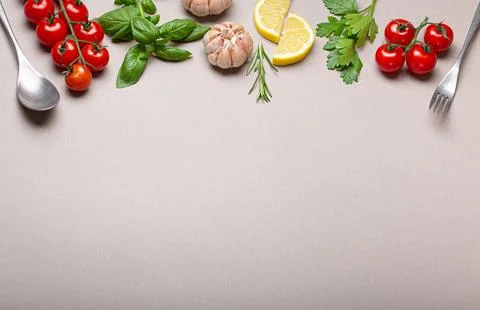 Composition with branch of fresh cherry tomatoes, herbs, garlic cloves, lem.. Stock Photos
