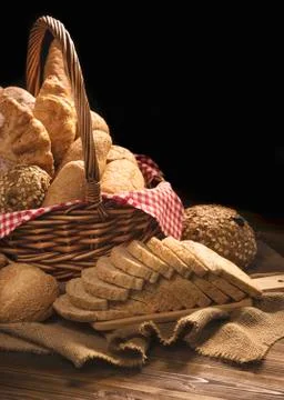 Composition with bread and rolls in wicker basket isolated on black Foto stock