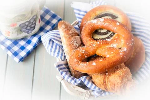 Composition with bread and rolls in wicker basket on wooden table Stock Photos